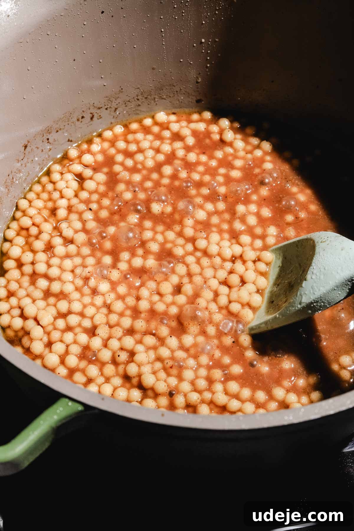 Lebanese Moghrabieh Pearl Couscous Delight 15 moghrabieh pearl couscous cooked in a chicken broth, inside a large pot with a spatula
