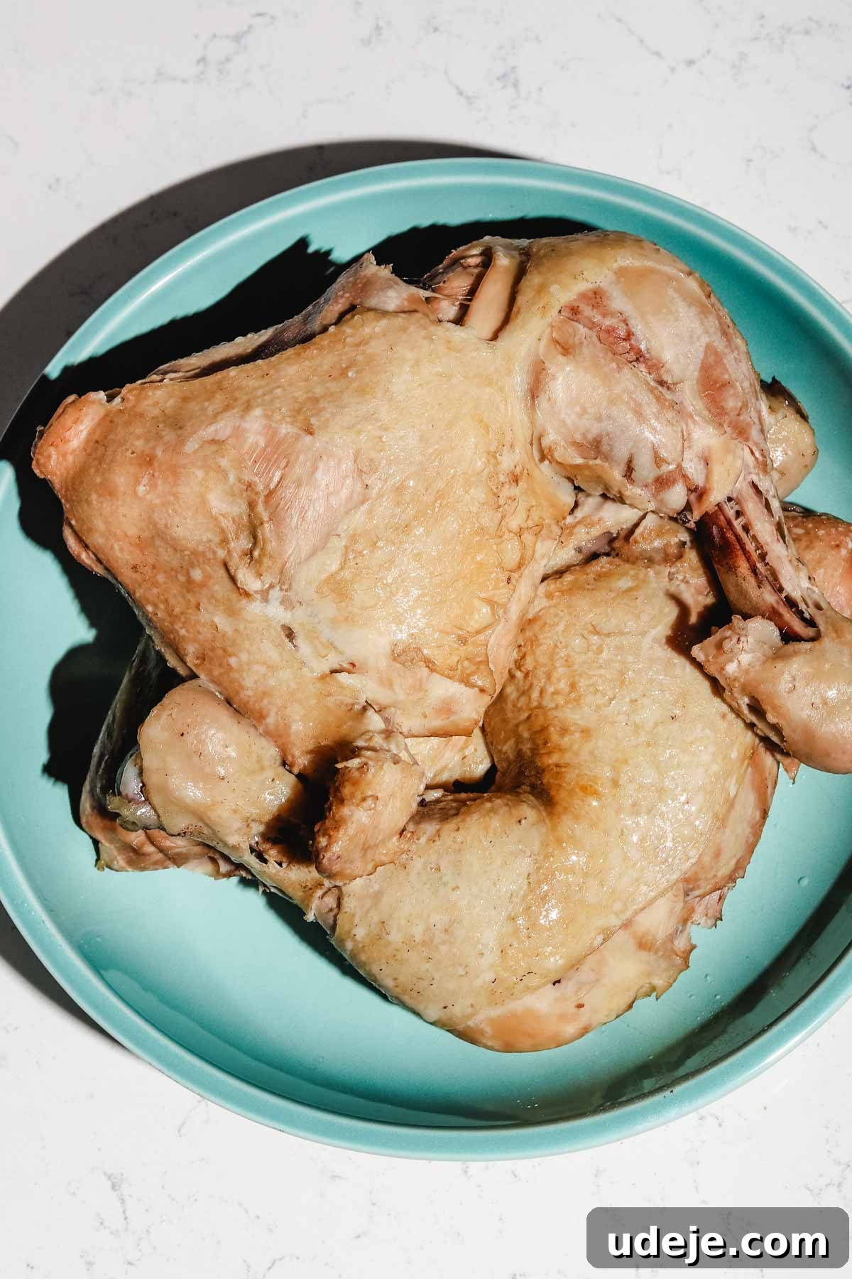 Lebanese Moghrabieh Pearl Couscous Delight 16 boiled skin on and bone in chicken legs in a blue plate