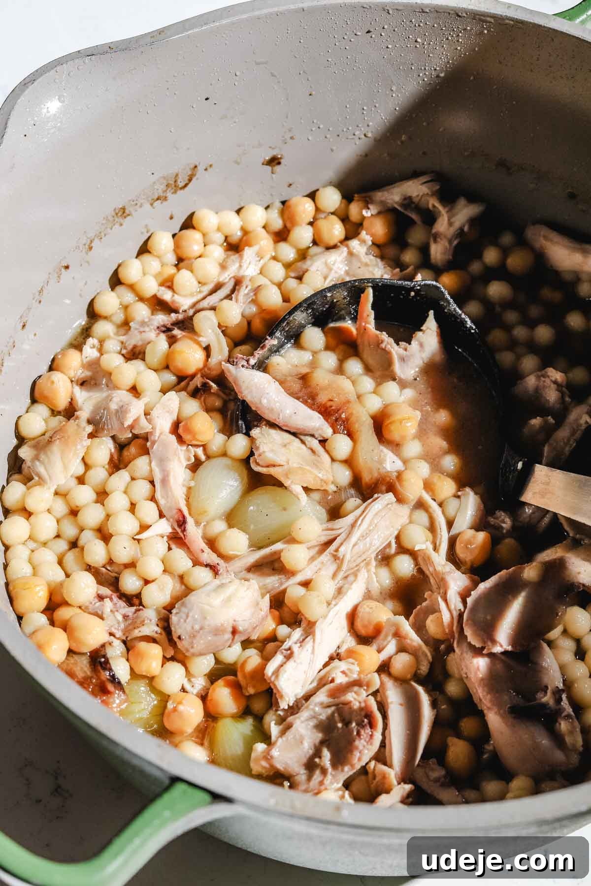 Lebanese Moghrabieh Pearl Couscous Delight 18 Moghrabieh stew with chicken in a large grey and green stock pot with a black ladle on a marble background
