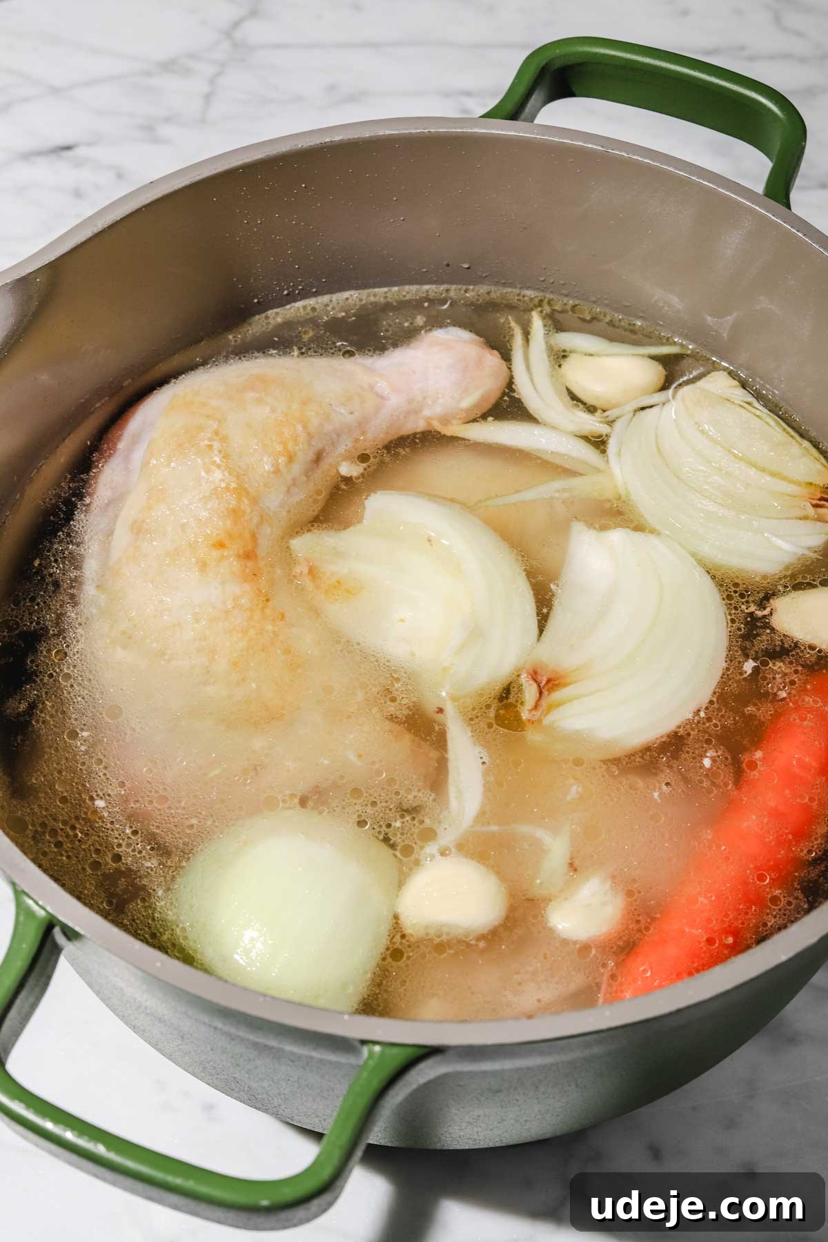 Lebanese Moghrabieh Pearl Couscous Delight 7 Chicken leg quarters, onion pieces, whole garlic cloves and whole carrots in water in a large grey and green stock pot