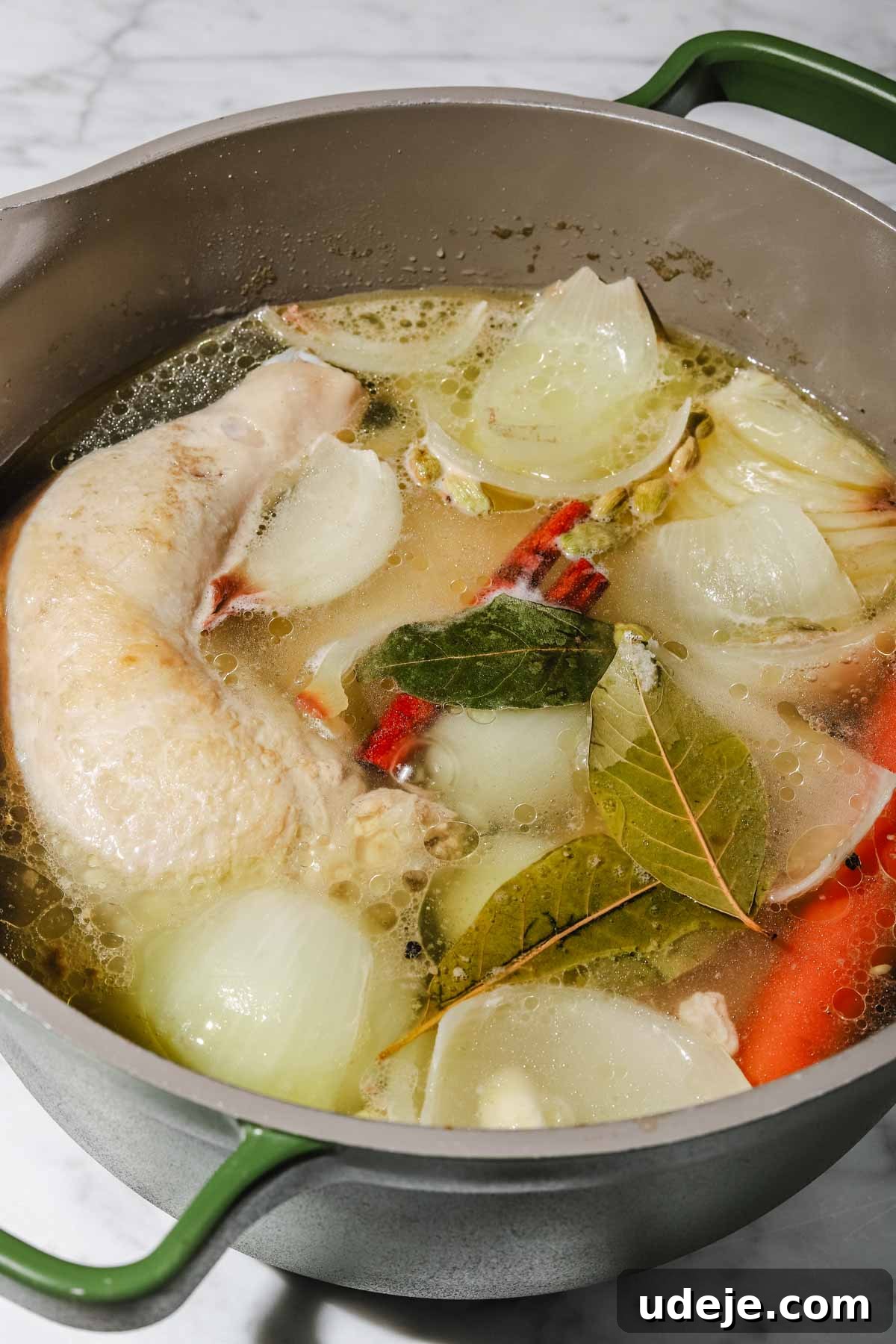 Lebanese Moghrabieh Pearl Couscous Delight 8 Chicken leg quarters, onion pieces, whole garlic cloves and whole carrots in water with cinnamon sticks, pepper corns and bay leaves simmering in a large grey and green stock pot