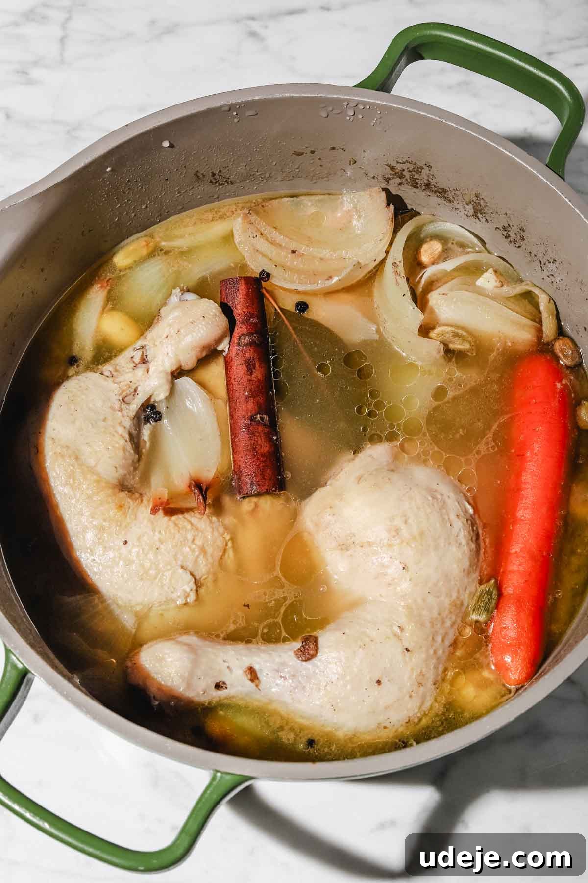 Lebanese Moghrabieh Pearl Couscous Delight 9 Chicken leg quarters, onion pieces, whole garlic cloves and whole carrots in water with cinnamon sticks, pepper corns and bay leaves simmering in a large grey and green stock pot