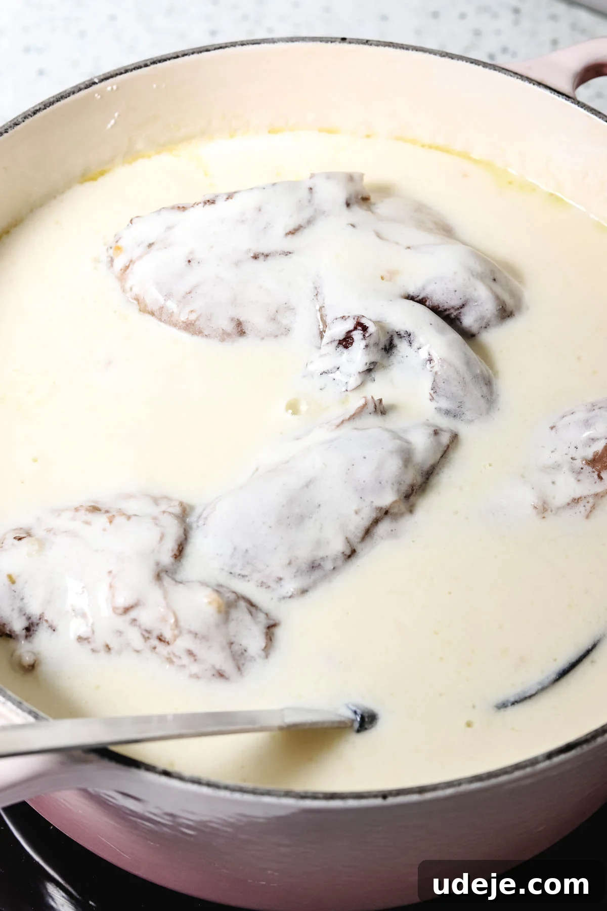 Syrian Shakriyeh: Velvety Lamb and Yogurt Stew 14 lamb shanks simmering in a yogurt stew inside a pink dutch oven