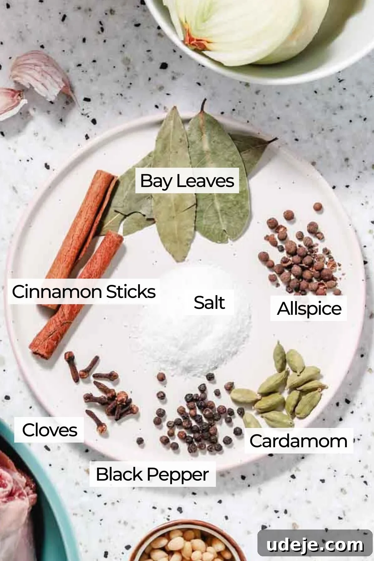 Syrian Shakriyeh: Velvety Lamb and Yogurt Stew 5 whole spices placed on a small platter which include allspice, cardamom, black pepper, cloves, cinnamon sticks and bay leaves