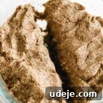 Kibbeh dough divided in half in a glass bowl on a light marble background