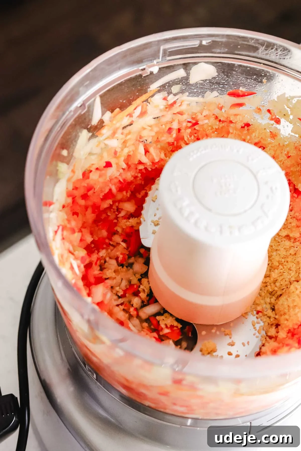 Baked Kibbeh Casserole 7 Onions and red peppers finely chopped in a food processor, demonstrating the initial blending stage for the kibbeh dough.