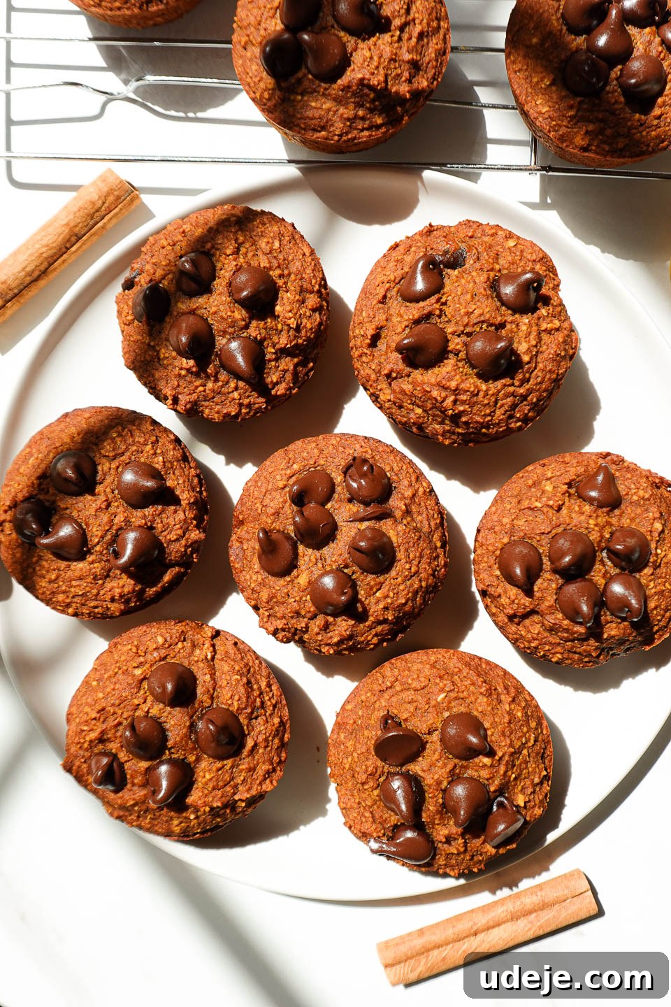 Delicious Plant Based Gluten Free Pumpkin Muffins 5 overhead shot of healthy pumpkin muffins on a plate garnished with a cinnamon stick