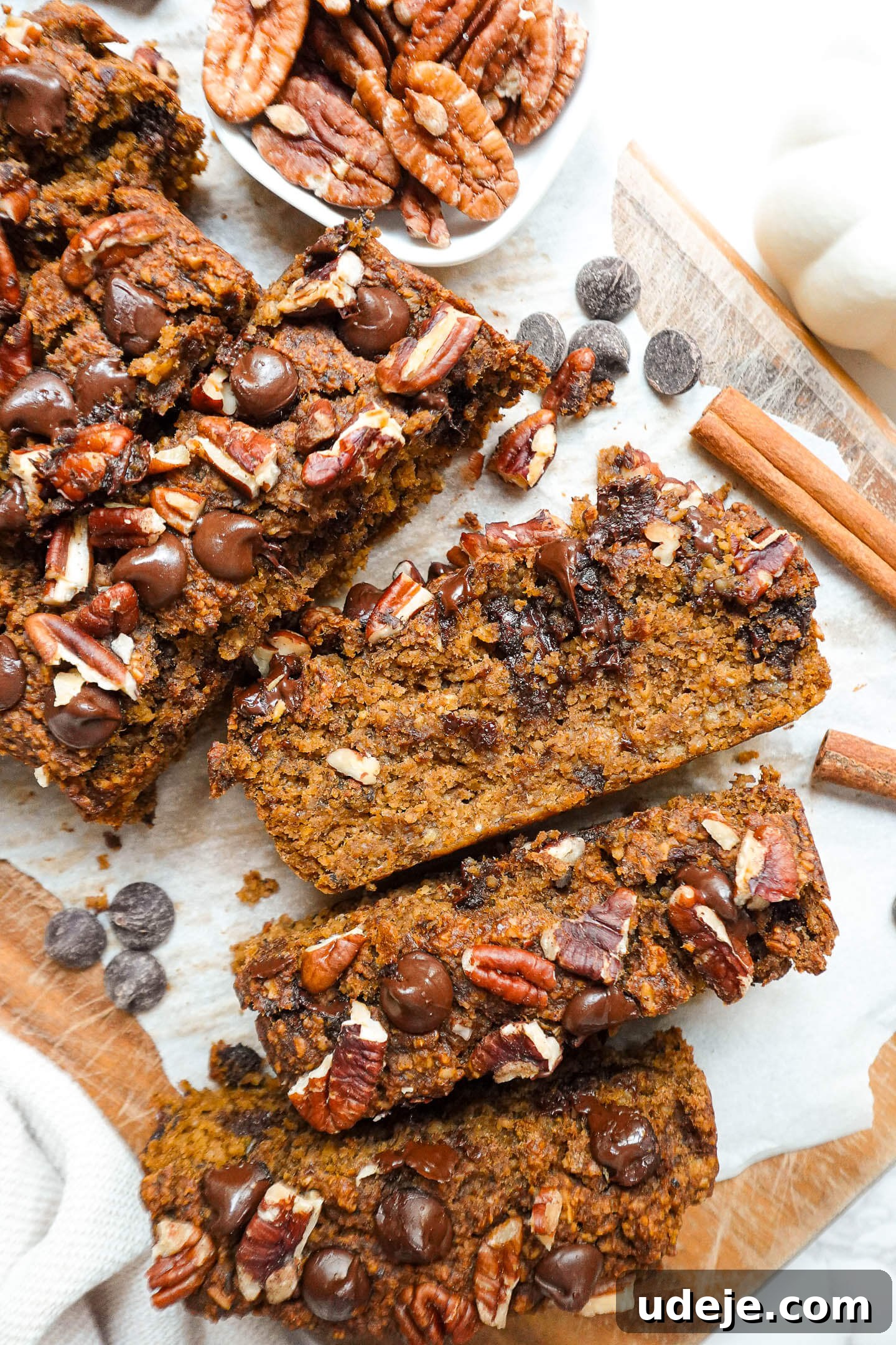 Warm Spiced Vegan Gluten Free Pumpkin Banana Bread 6 Slices of moist pumpkin spice banana bread with a soft, fluffy texture, showing rich pockets of chocolate chips and pecans.