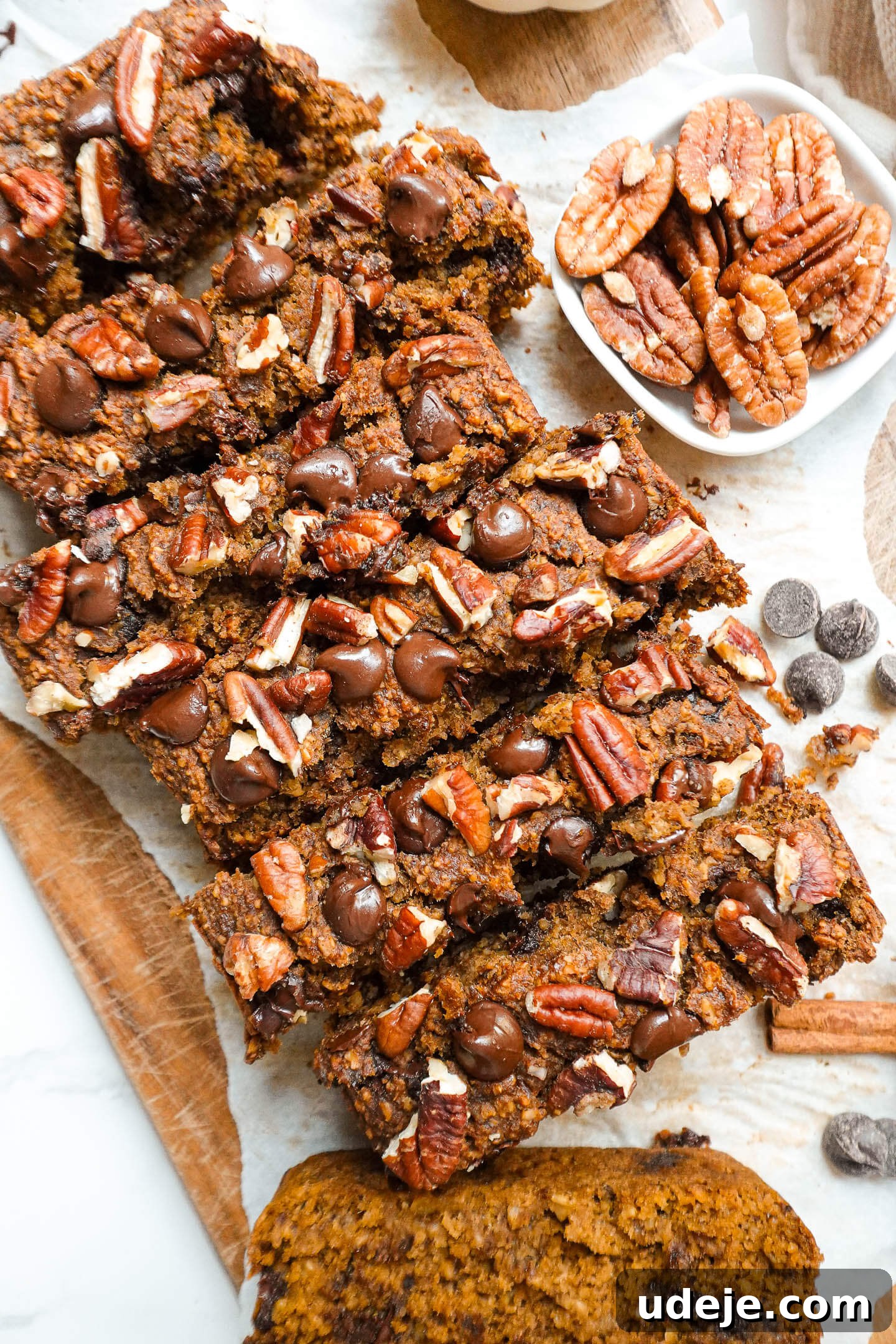 Warm Spiced Vegan Gluten Free Pumpkin Banana Bread 7 Slices of moist pumpkin spice banana bread with a soft, fluffy texture, showing rich pockets of chocolate chips and pecans.
