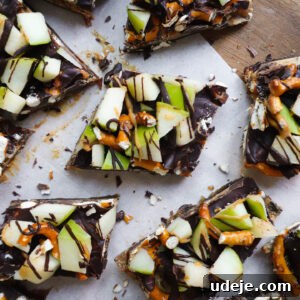 Finished caramel apple date bark cut into pieces and ready to be enjoyed, with a mix of sweet and salty toppings.