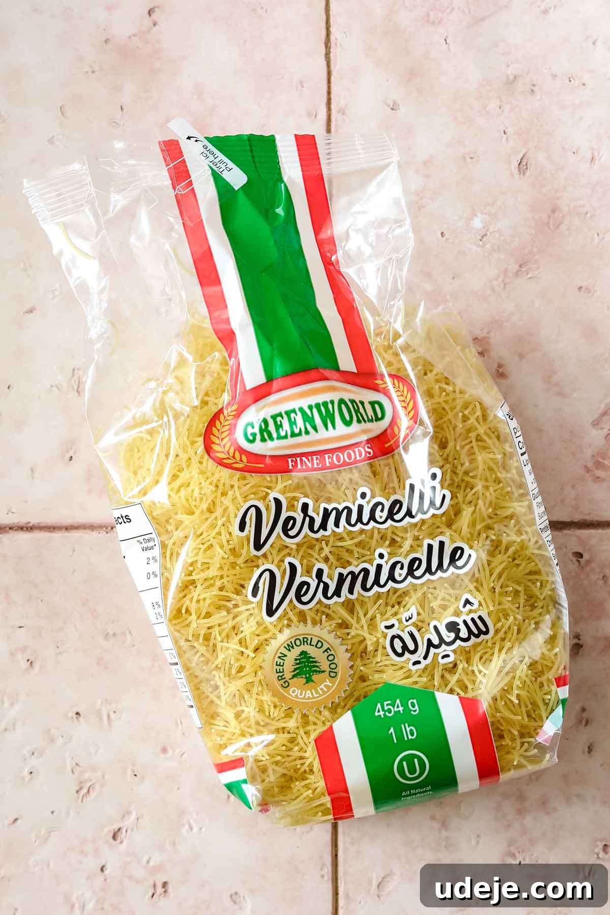 Quick Tomato Vermicelli Delight 3 A vibrant pink tiled background sets the stage for a neatly packaged bundle of vermicelli noodles, ready to be transformed into a delicious meal.