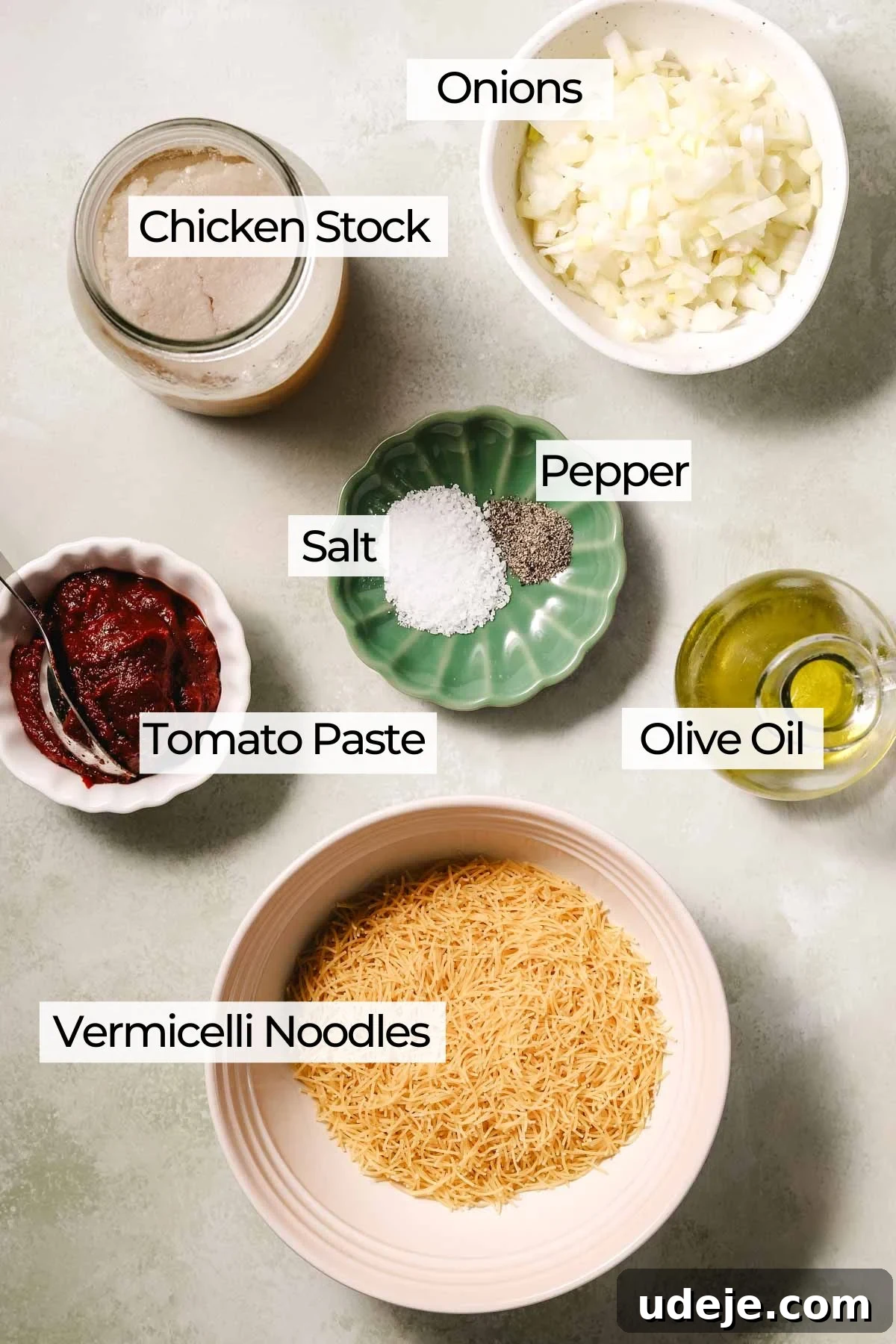 Quick Tomato Vermicelli Delight 4 A vibrant flat lay showcasing the simple yet essential ingredients for tomato vermicelli soup: diced onions, rich chicken stock, salt, pepper, golden olive oil, concentrated tomato paste, and delicate vermicelli noodles.