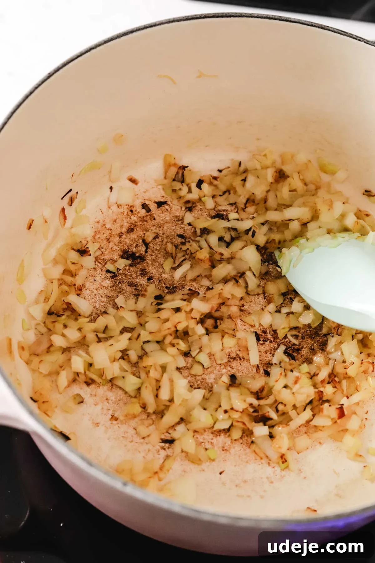 Quick Tomato Vermicelli Delight 6 Finely diced onions gently softening in olive oil within a soup pot, stirred with a spatula, creating an aromatic foundation.