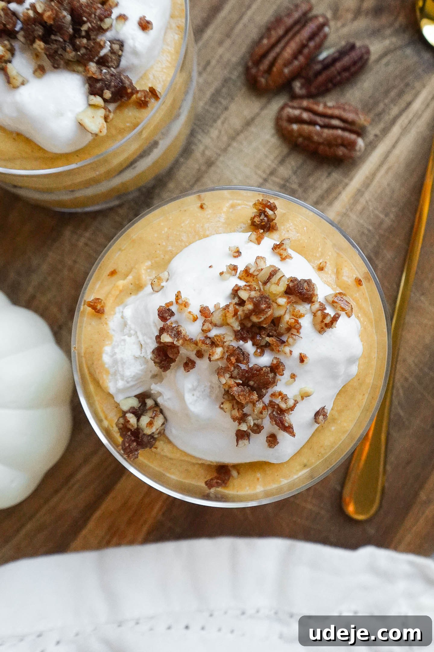 Effortless Vegan Pumpkin Cheesecake Trifle 6 Close-up of no-bake vegan pumpkin cheesecake trifle with layers of pumpkin cheesecake and coconut whipped cream topped with pecan date crumble