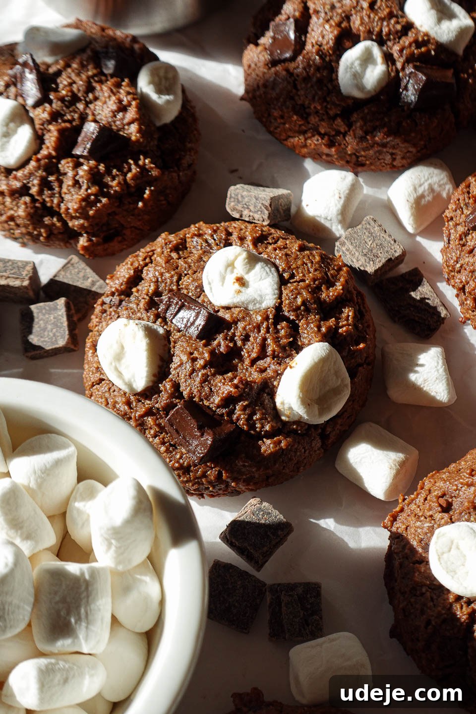 Ultra Fudgy Vegan Gluten Free Hot Cocoa Cookies 4 Close-up of a vegan and gluten-free hot chocolate cookie topped with chocolate chunks and marshmallows, highlighting its soft, chewy texture.