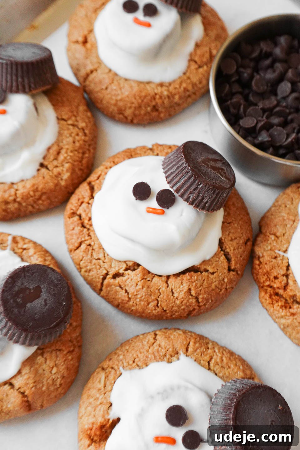 Whimsical Vegan Gluten Free Melted Snowman Cookies 4 Close-up of a melted snowman cookie with a peanut butter cup hat and an orange sprinkle carrot nose, showcasing the whimsical details.