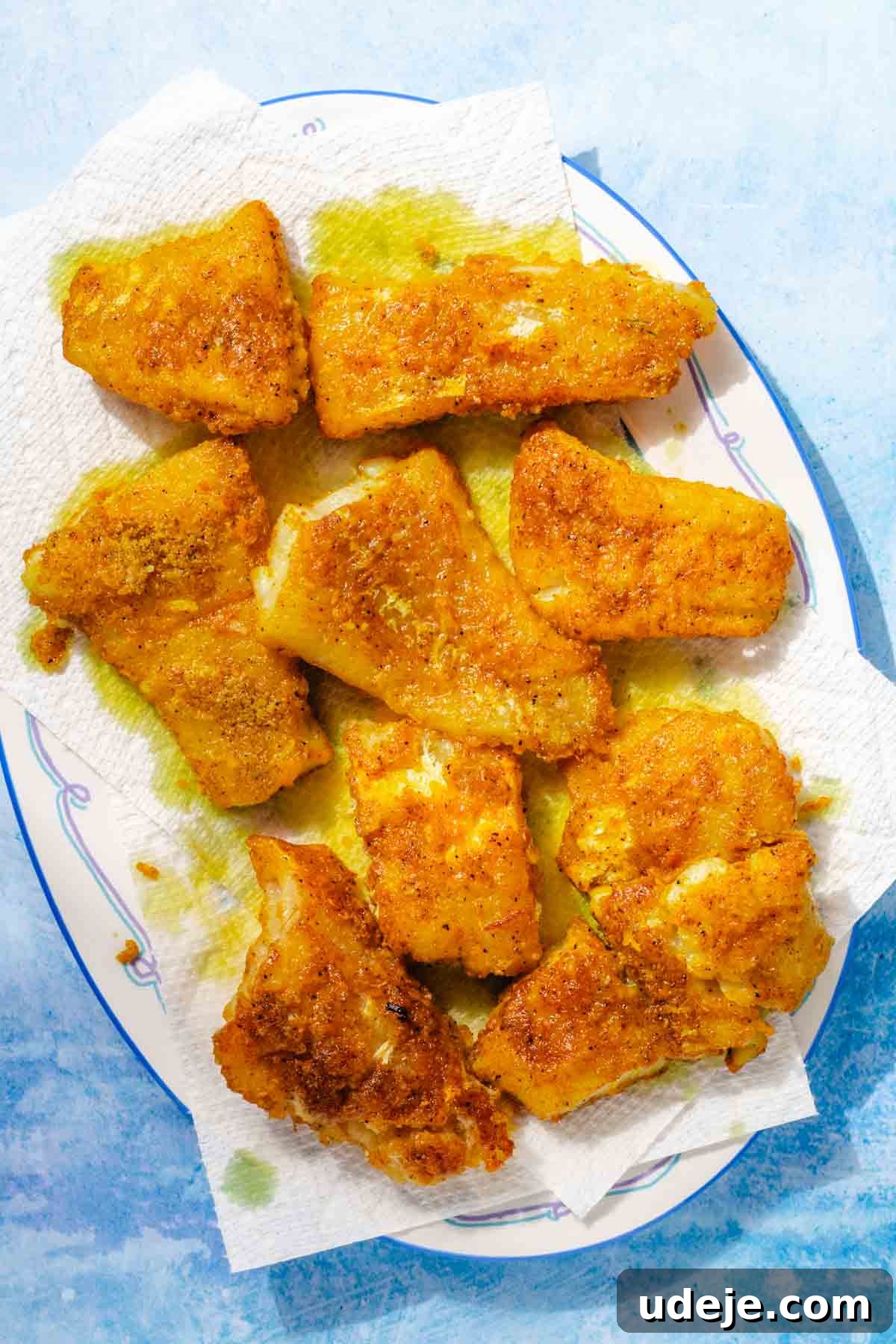 Fragrant Middle Eastern Fish Pilaf 16 Fried cod fillets on paper towels on a white and blue patterned platter on a blue background