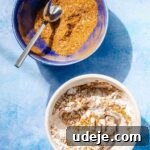Fragrant Middle Eastern Fish Pilaf 24 Mixed spice in a blue bowl with a metal spoon beside a white bowl with some spices and cornstarch and a metal spoon on a blue background