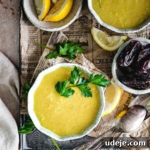 Middle Eastern Lentil Soup Two Ways 8 Creamy yellow lentil soup served in a bowl, presented on a tray with fresh dates and lemon wedges.