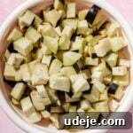 Speedy Moroccan Eggplant Zaalouk 4 Eggplants cubed in a white bowl on a pink background