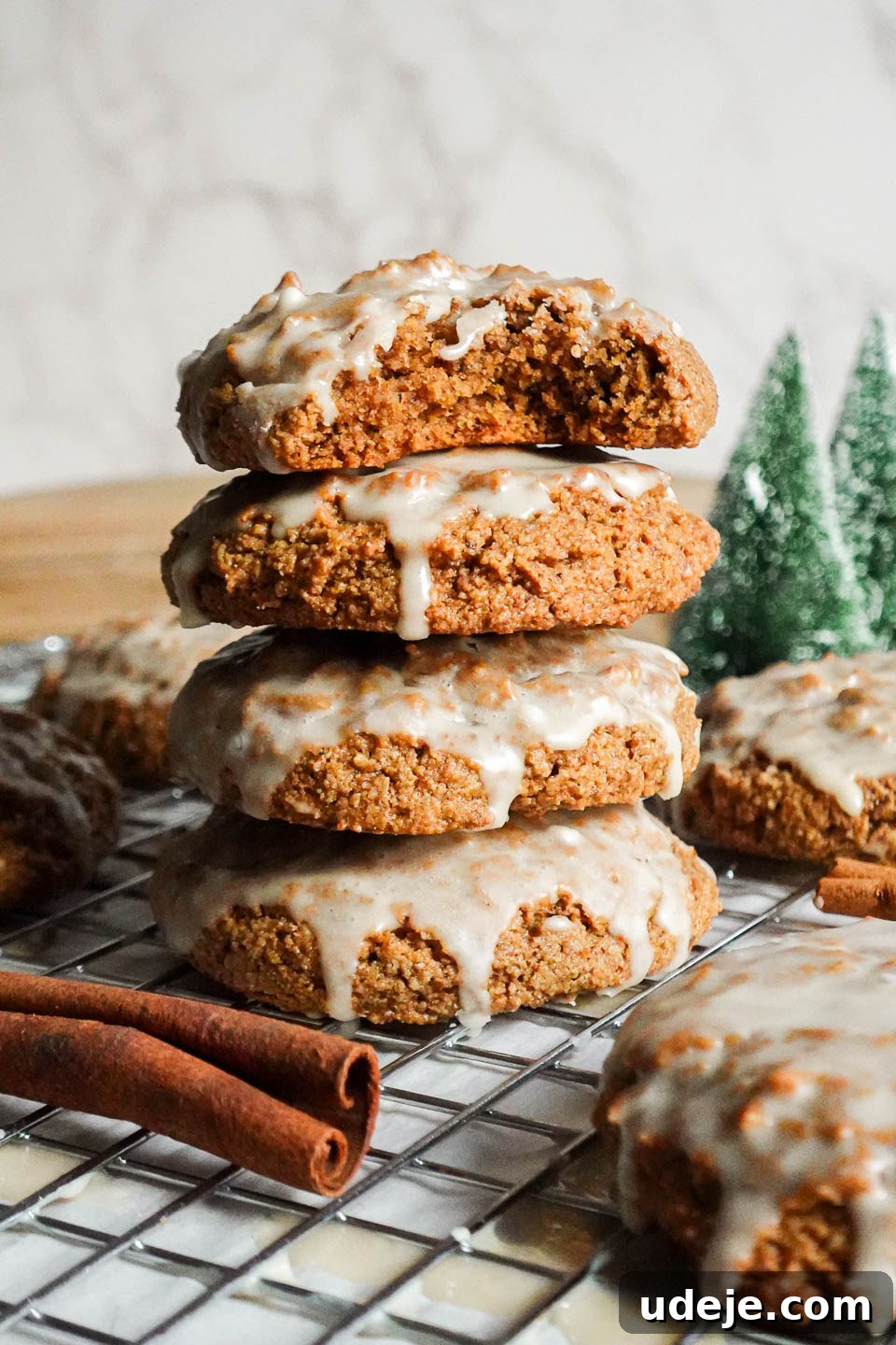 Delicious Vegan Gluten-Free Iced Gingerbread Cookies 2 Stack of round, soft iced gingerbread cookies with a bite taken out of the top cookie, showing a fluffy interior.