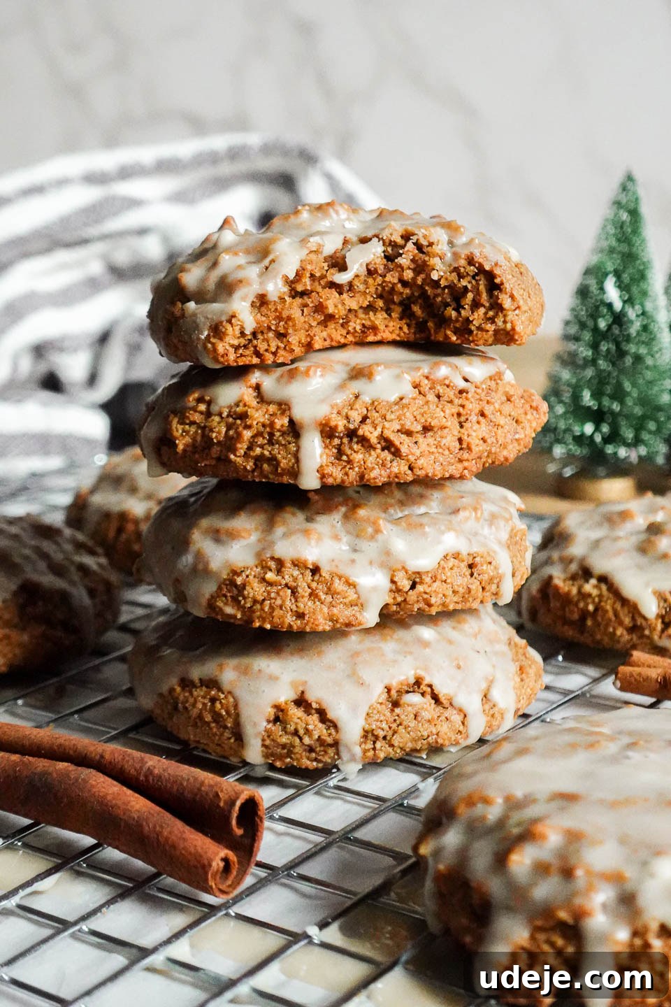 Delicious Vegan Gluten-Free Iced Gingerbread Cookies 4 Close-up of stacked soft vegan and gluten-free iced gingerbread cookies with a bite taken out, revealing the light and fluffy texture inside.
