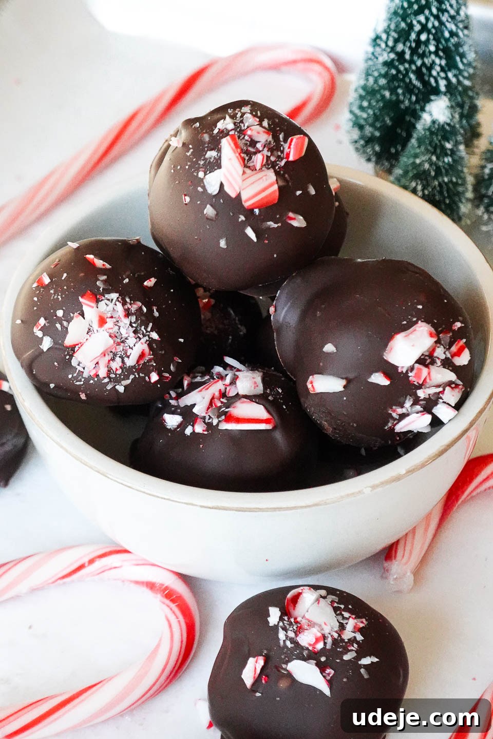 Dark Chocolate Peppermint Dreams 2 Rich and creamy vegan chocolate peppermint truffles, beautifully coated in melted chocolate and generously sprinkled with vibrant crushed peppermint candies, ready to be enjoyed as a holiday dessert.