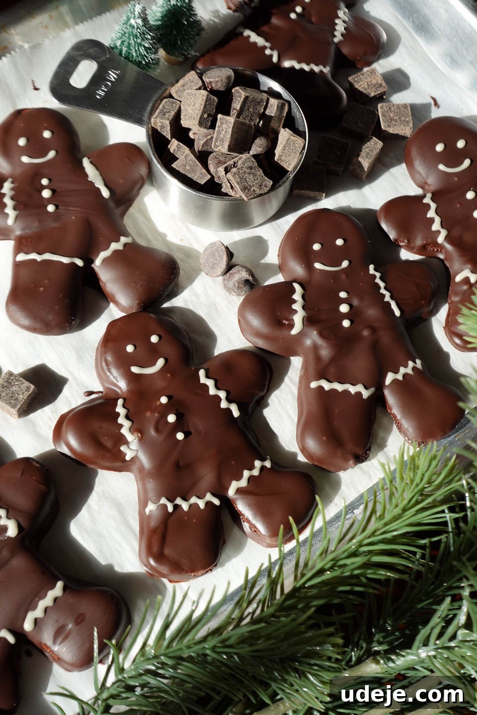 Decadent Vegan Gluten-Free Peppermint Chocolate Delights 3 Festive vegan chocolate peppermint cookies in the shape of gingerbread men, coated in melted chocolate and adorned with white chocolate decorations