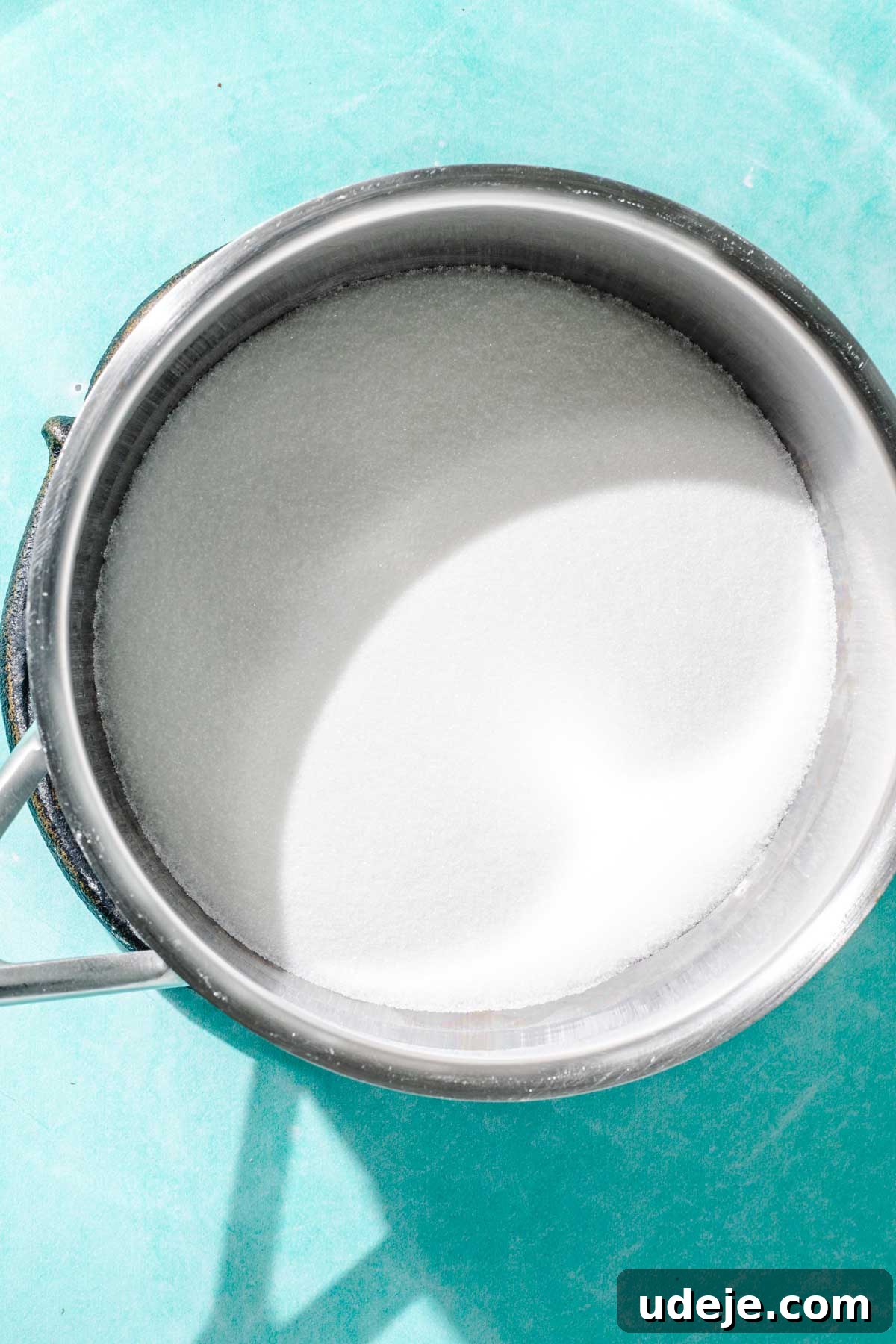 Heavenly Turkish Milk Cake 14 Sugar in a metal saucepan on a blue background
