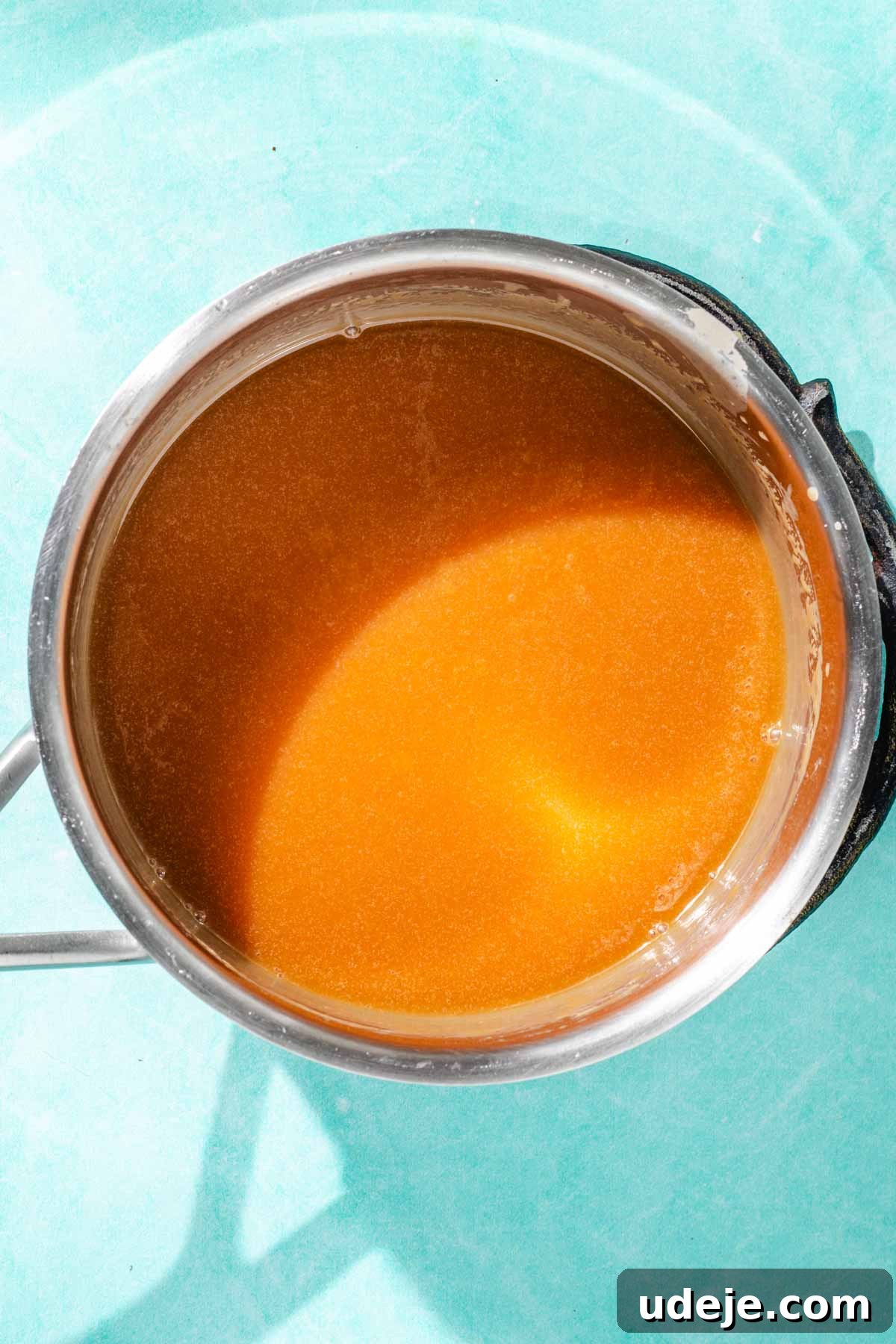 Heavenly Turkish Milk Cake 16 Caramel sauce in a metal saucepan on a blue background