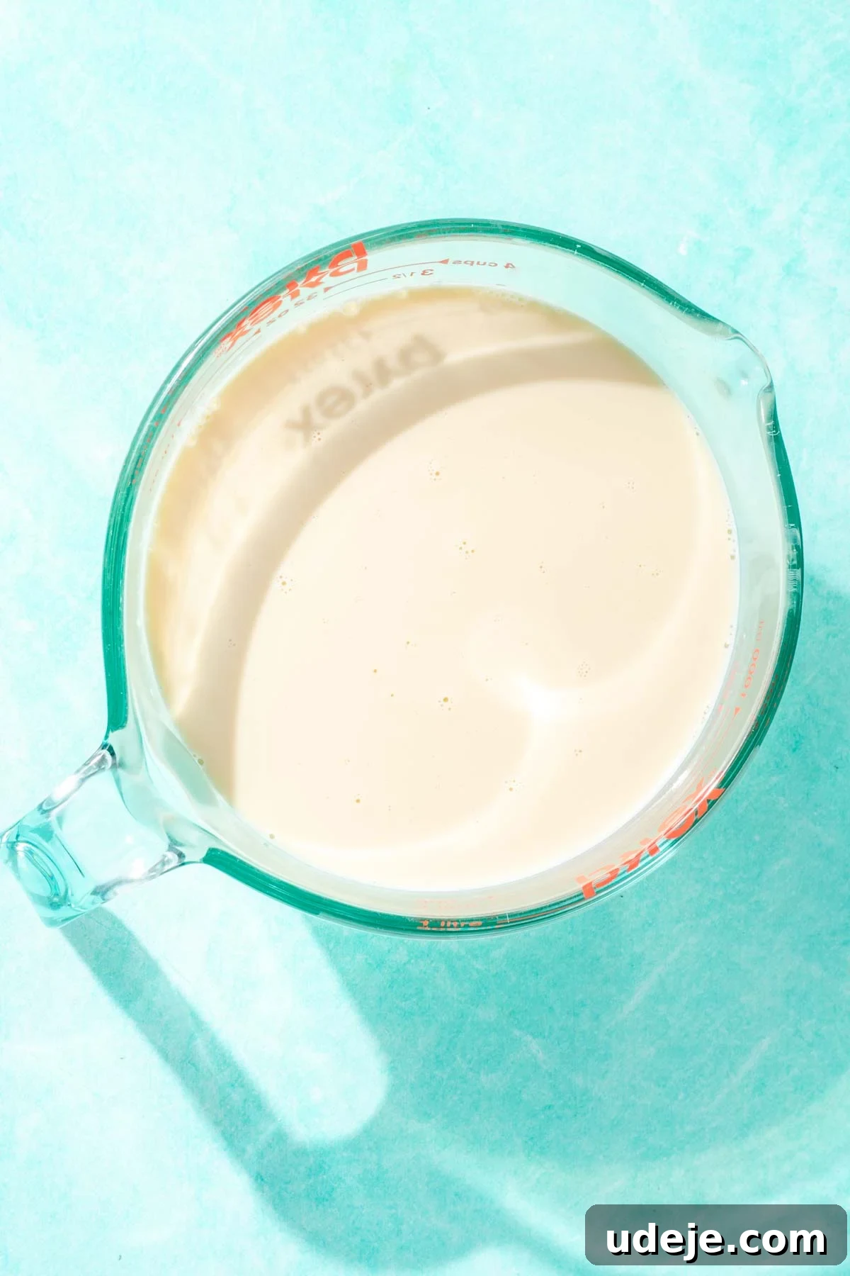 Heavenly Turkish Milk Cake 17 Milk in a large glass measuring cup on a blue background