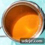Caramel sauce in a metal saucepan on a blue background