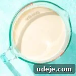 Milk in a large glass measuring cup on a blue background