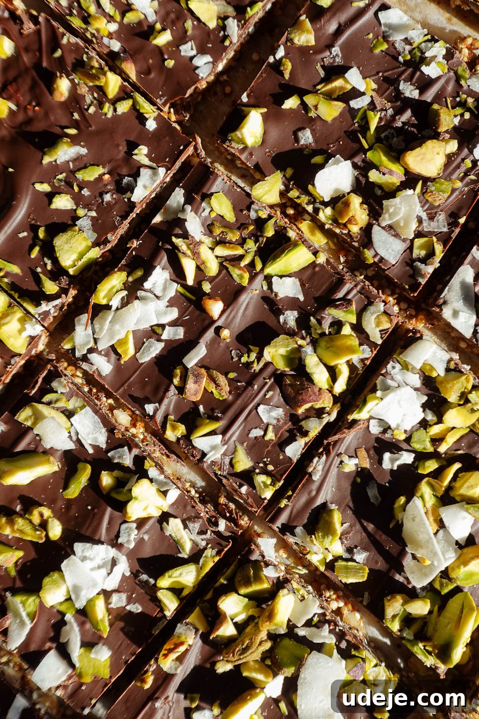 Wholesome Chocolate Quinoa Crunch Bark 2 A close-up of broken pieces of chocolate quinoa bark, showing the layers of dark chocolate and crunchy nuts and seeds. The texture is inviting and rich.