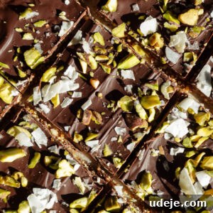Wholesome Chocolate Quinoa Crunch Bark 6 A close-up of broken pieces of chocolate quinoa bark, showing the layers of dark chocolate and crunchy nuts and seeds