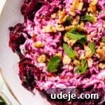 Vibrant Beetroot Yogurt Salad 14 Turkish beet salad garnished with walnuts and mint in a white salad bowl on a green background