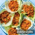 Kisir in lettuce cups on a bue patterned plate on a blue background