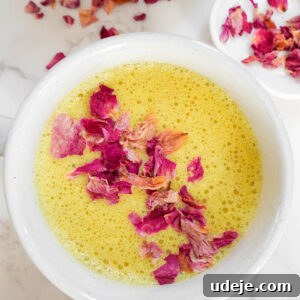 A top-down view of a cup of Golden Milk, showcasing its frothy texture and inviting golden color, ready to be enjoyed.