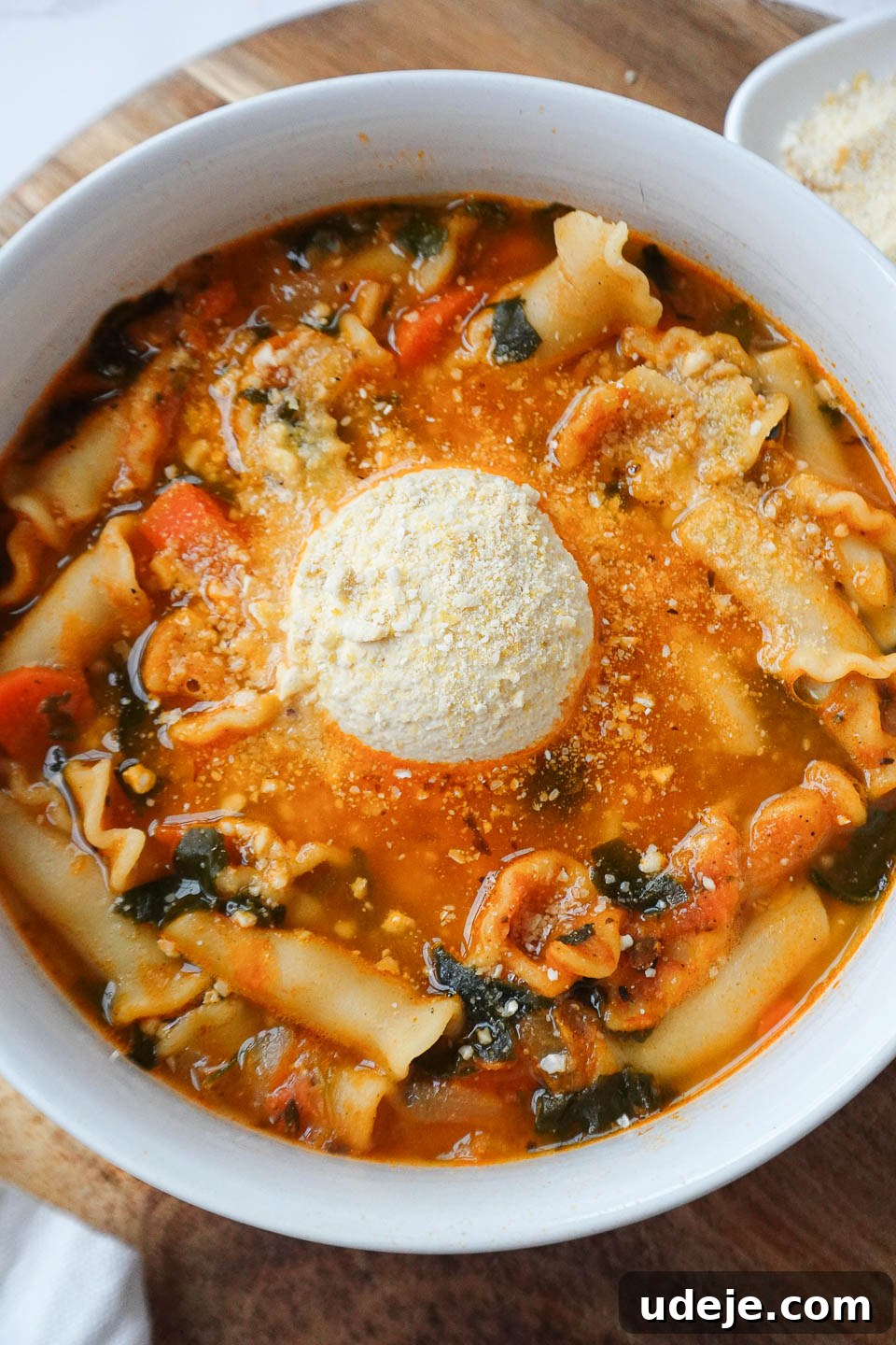 Simple One Pot Vegan Lasagna Soup 3 A comforting bowl of vegan lasagna soup, generously topped with creamy homemade tofu ricotta and a sprinkle of savory cashew parmesan, ready to be enjoyed.