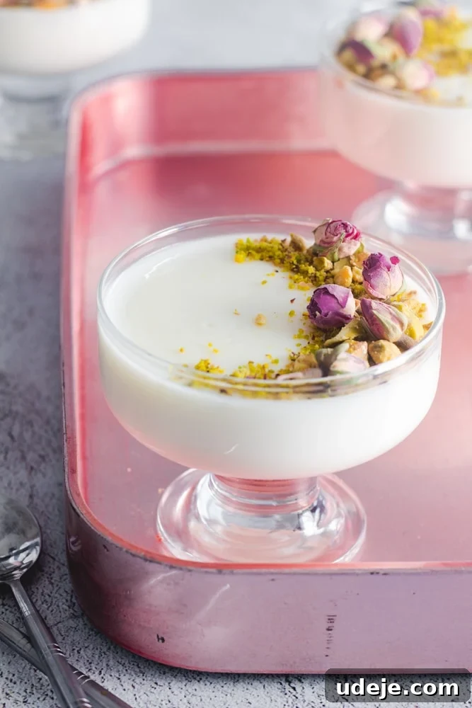 Mahalabia Silky Smooth Middle Eastern Pudding 2 Mahalabia (or Muhallebi) Milk Pudding in a serving cup garnished with pistachio and rose buds, offering a visually appealing and delicious dessert experience.
