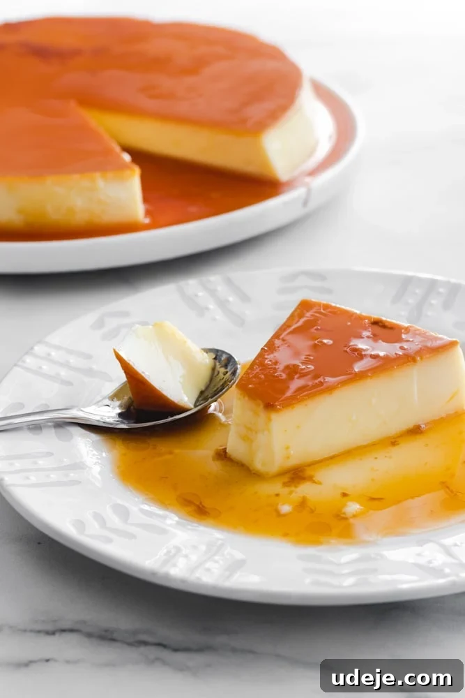 Creamy Condensed Milk Creme Caramel 2 Creme caramel slice on a plate, with one bite taken out using a spoon. The full creme caramel on a platter in the back.