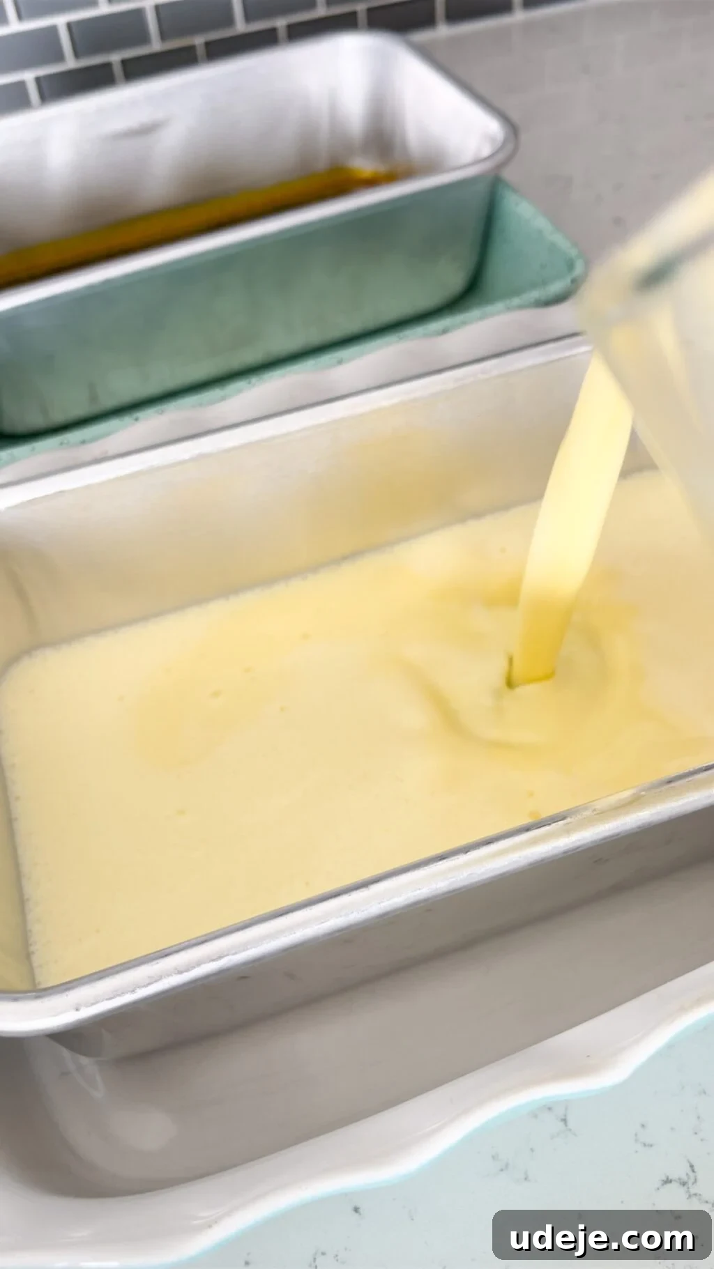 Creamy Condensed Milk Creme Caramel 15 custard being poured from a jug into a silver loaf pan