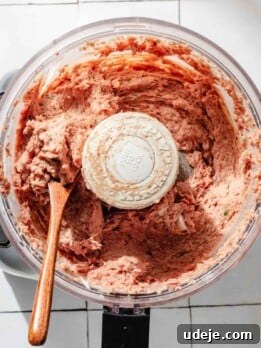 One-Pan Lamb and Beef Doner Kebab 22 Pureed doner kebab meat mixture in a food processor with a wooden spoon on a white tiled background