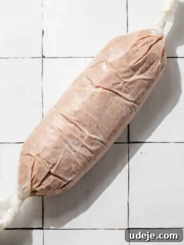 One-Pan Lamb and Beef Doner Kebab 23 Doner Kebab in a log shape wrapped in parchment on a white tiled background