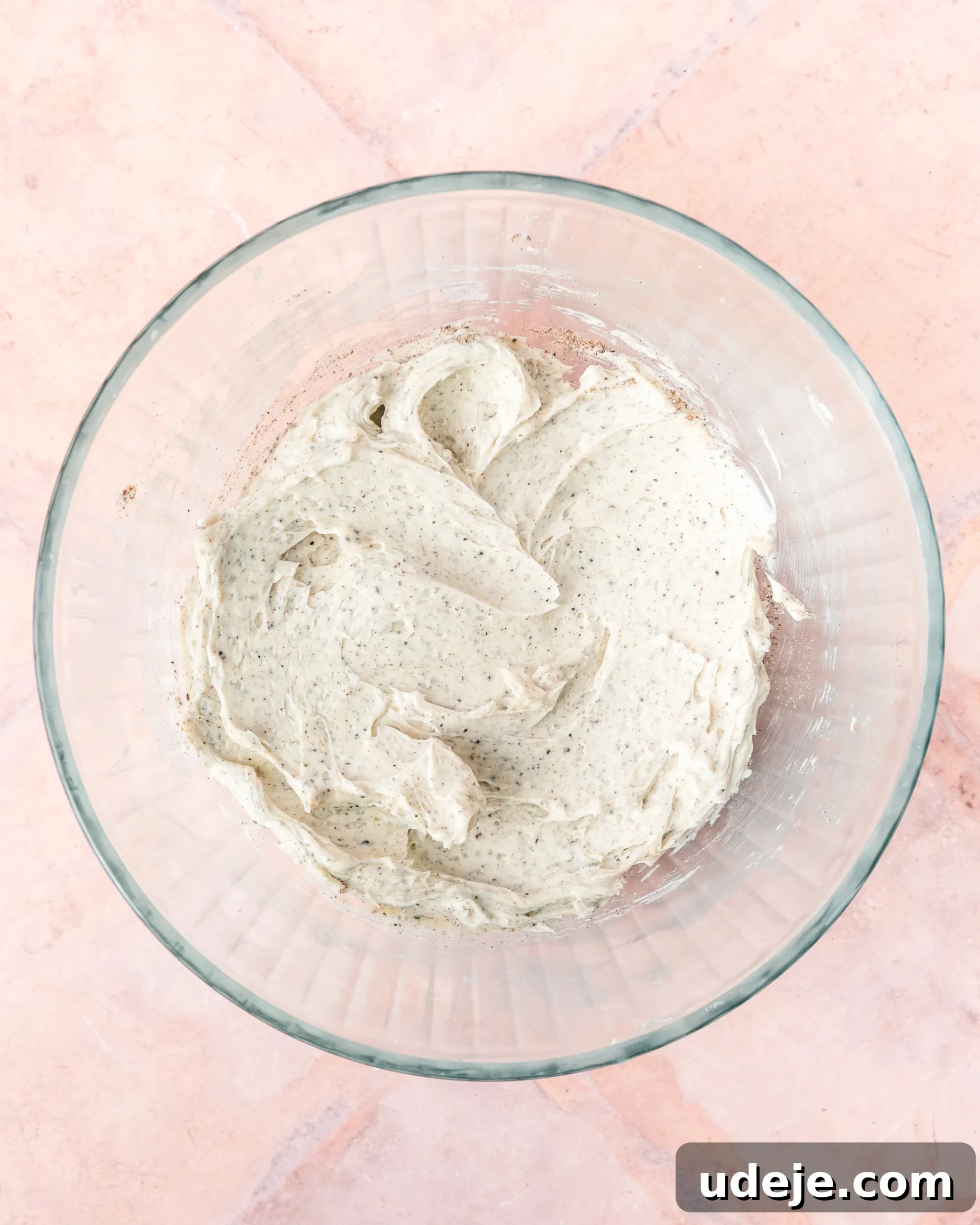Fragrant Cardamom Shortbread Cookies 8 Creamed butter with cardamom and baking powder in a glass bowl on a light red tiled background.