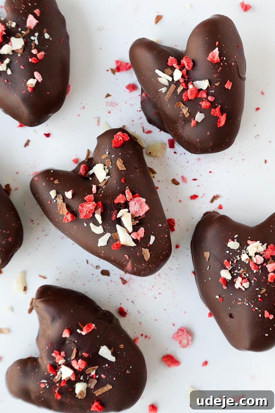 Decadent Chocolate Date Gems 2 Close-up of heart-shaped Medjool dates, beautifully stuffed with creamy peanut butter and coated in luxurious dark chocolate – a perfect healthy Valentine's Day dessert or anytime treat.