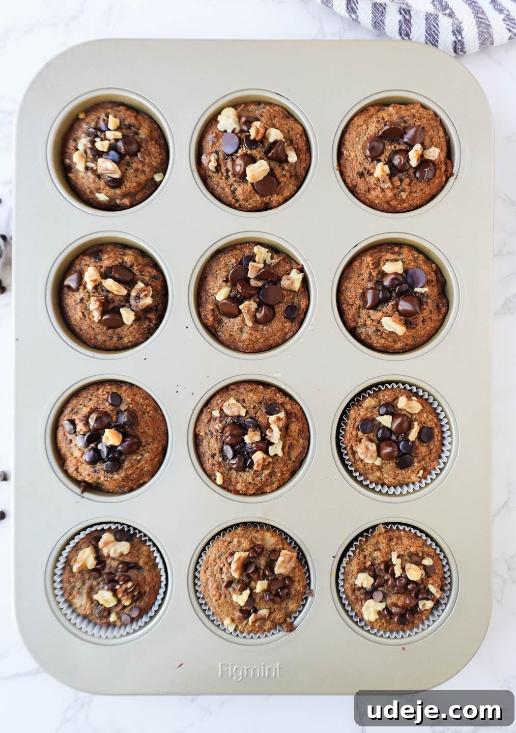 Deliciously Wholesome Vegan Gluten-Free Banana Muffins 4 Freshly baked healthy banana muffins in a muffin tin, topped with chopped walnuts and chocolate chips