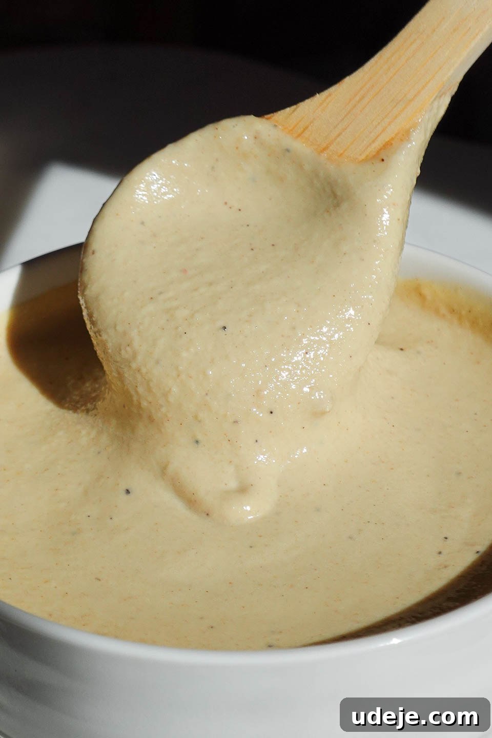 Bright Lemon Tahini Dressing 4 Spoon drizzling creamy lemon tahini dressing over a dish