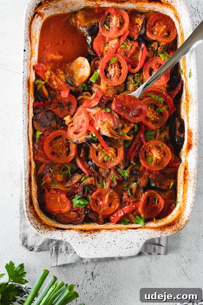 Mediterranean Eggplant Kofta Casserole 3 A close-up shot of Mediterranean Eggplant Casserole in a baking dish, highlighting its rich layers and glossy tomato sauce, with a serving spoon poised.