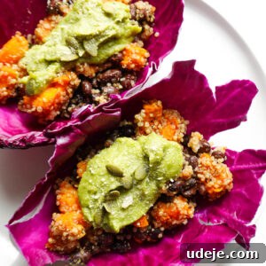 Close-up of hearty quinoa, roasted sweet potato, and black beans tacos wrapped in red cabbage leaves.